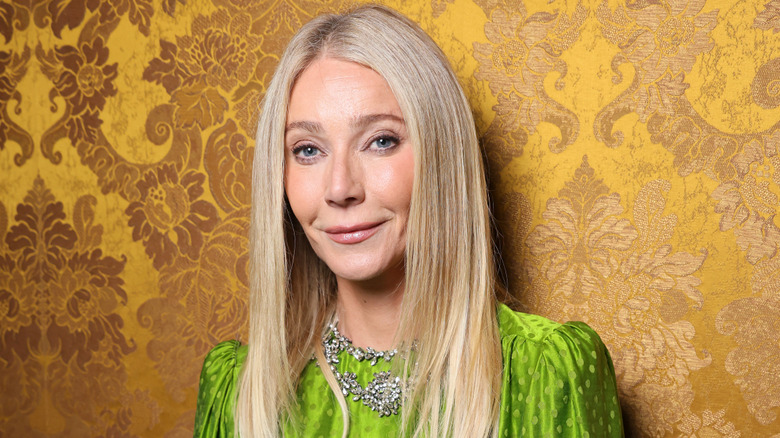 Gwyneth Paltrow bright green top in front of yellow wallpaper