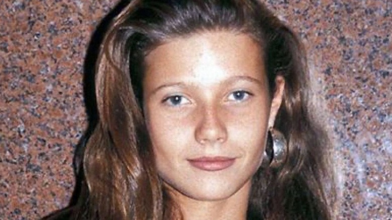Gwyneth Paltrow with brunette hair and large hoop earrings in 1989