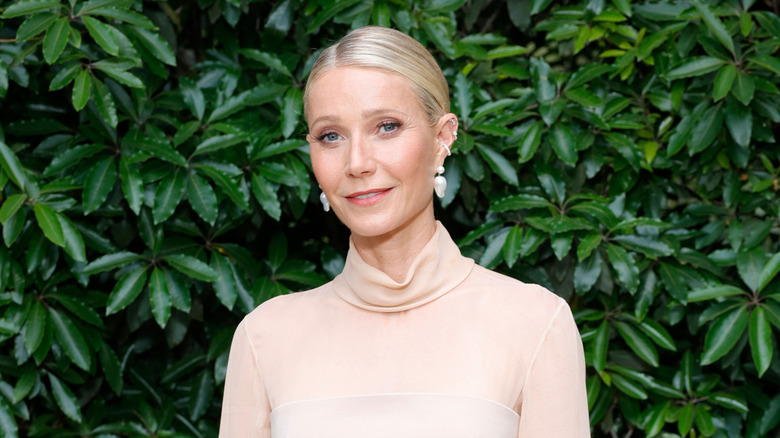 Gwyneth Paltrow posing in front of leaves