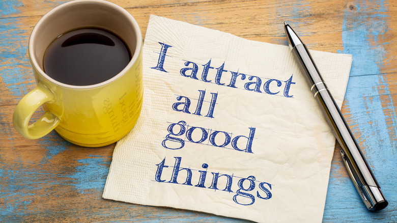 coffee cup near napkin and pen