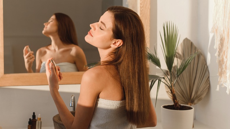 Woman spraying on perfume