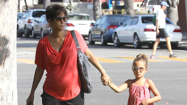 Halle Berry holding the hand of her daughter