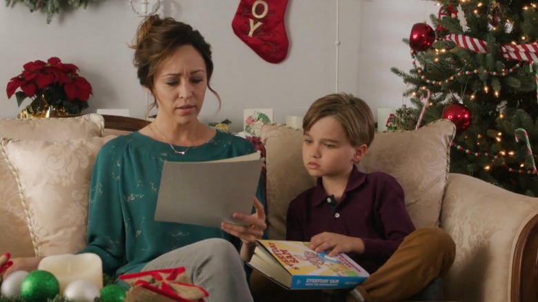 Autumn Reeser and Liam Hughes sitting on a couch looking at books