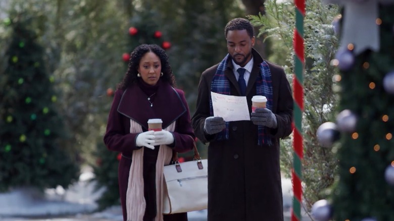 Tamera Mowry-Housley and Ronnie Rowe walking together with Christmas trees in the bakground