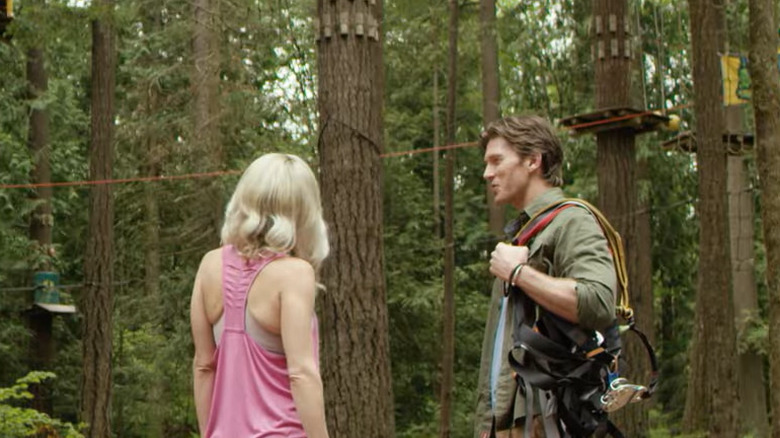 A blond woman standing next to a man with a climbing harness slung over his shoulder