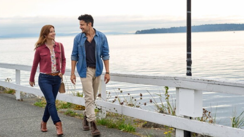Stacey Farber as Amy (left) and Tyler Hynes as Mark (right) walking in "I'll Be Seeing You"