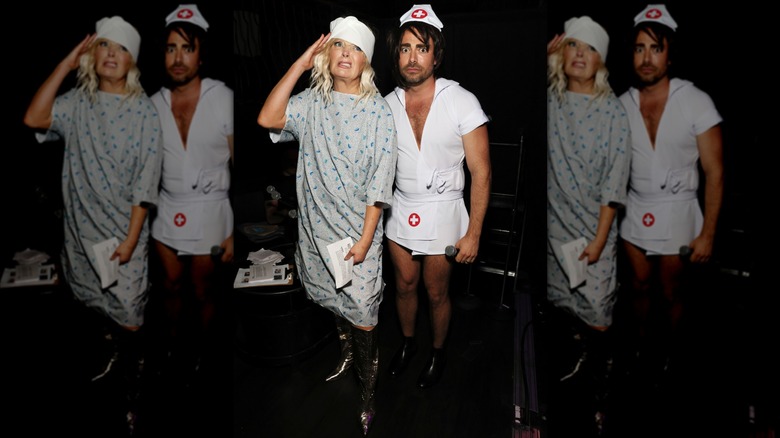 Melissa Peterman wearing a hospital gown and Jonathan Bennett wearing a nurse costume.