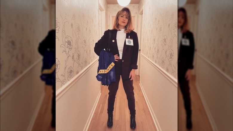 Bethany Joy Lenz wearing an FBI agent costume in a hallway.