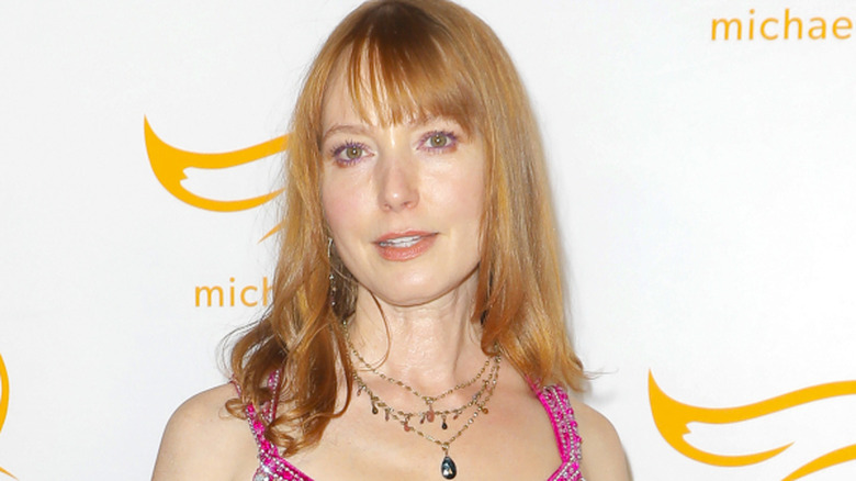 Alicia Witt posing in front of a white background