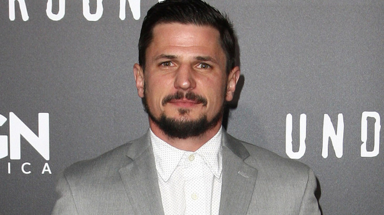 Marc Blucas posing in front of a grey background