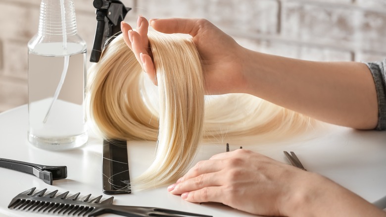 Stylist holding blonde hair piece