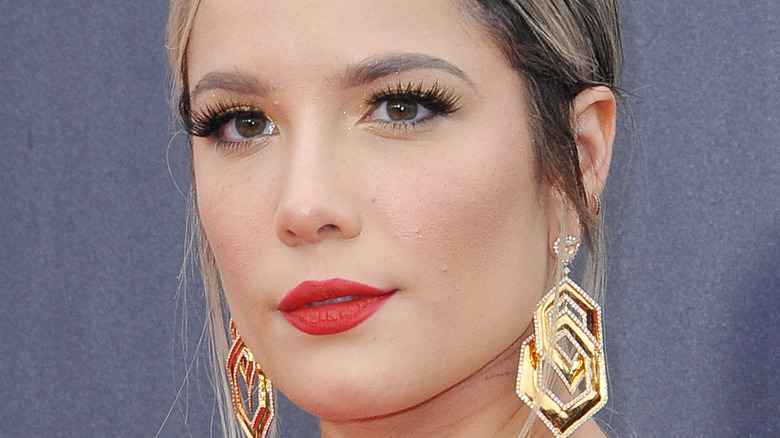 Halsey wears a red lip and gold earrings