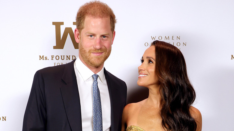 Meghan Markle gold dress looking up at Prince Harry