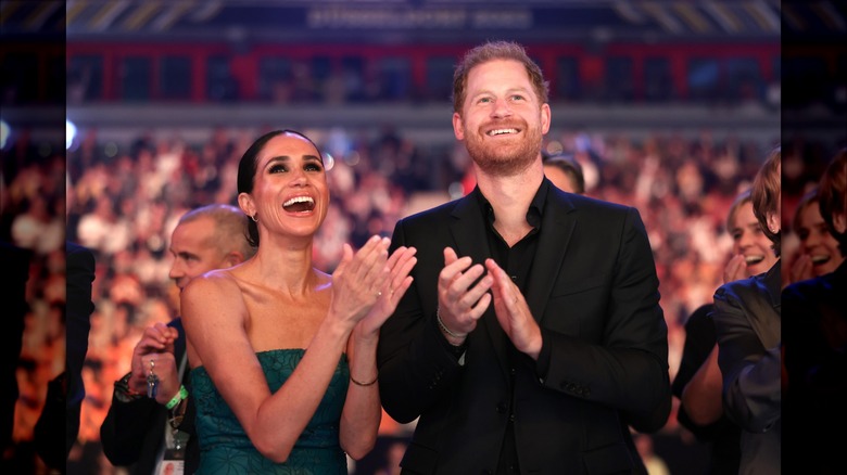Meghan and Harry clapping and smiling