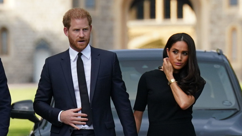 Prince Harry and Meghan Markle walking hand-in-hand outside of Windsor Castle