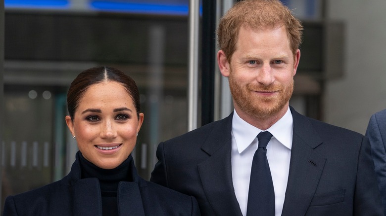 Prince Harry and Meghan Markle outside and smiling