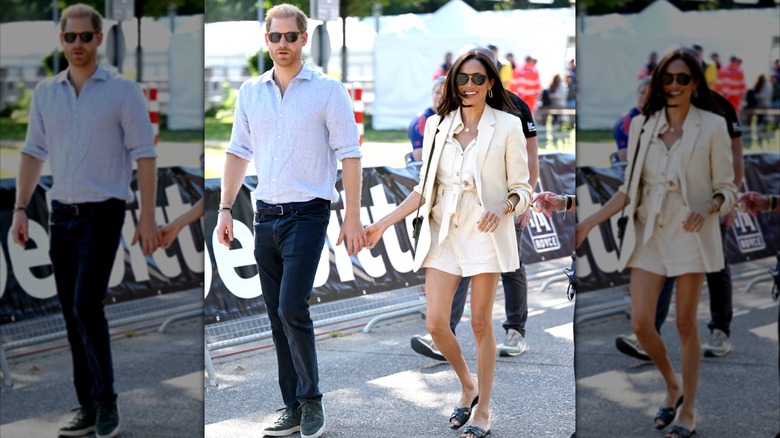 Prince Harry and Meghan Markle hold hands while walking
