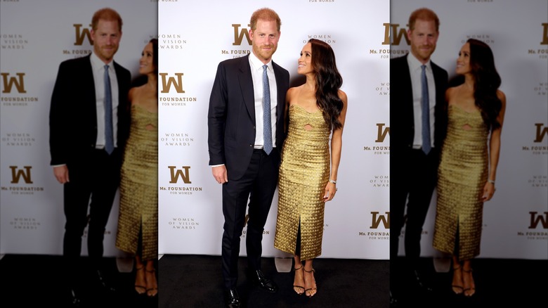 Prince Harry and Meghan Markle smile on red carpet