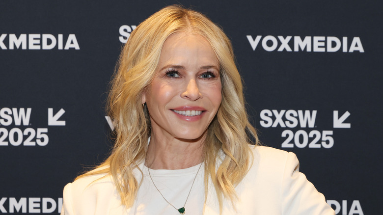 Chelsea Handler smiling in a white jacket and shirt at the