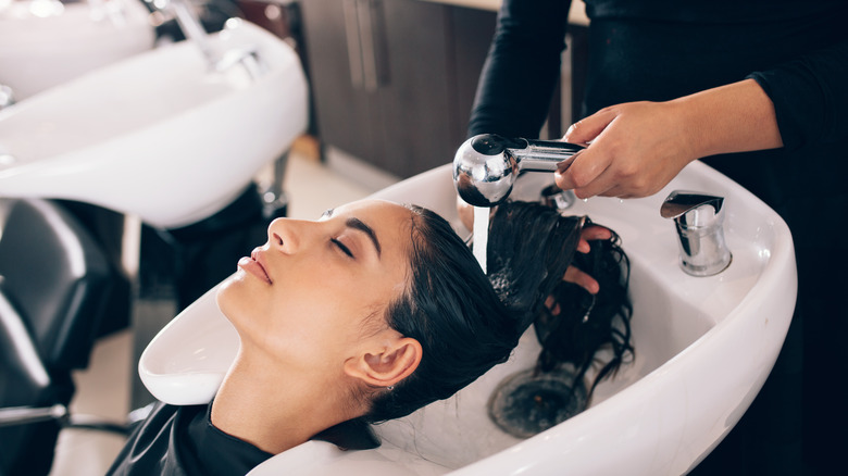 woman getting hair rinsed at a salon