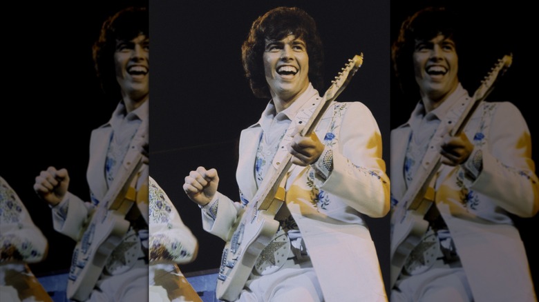 Alan osmond smiling with guitar