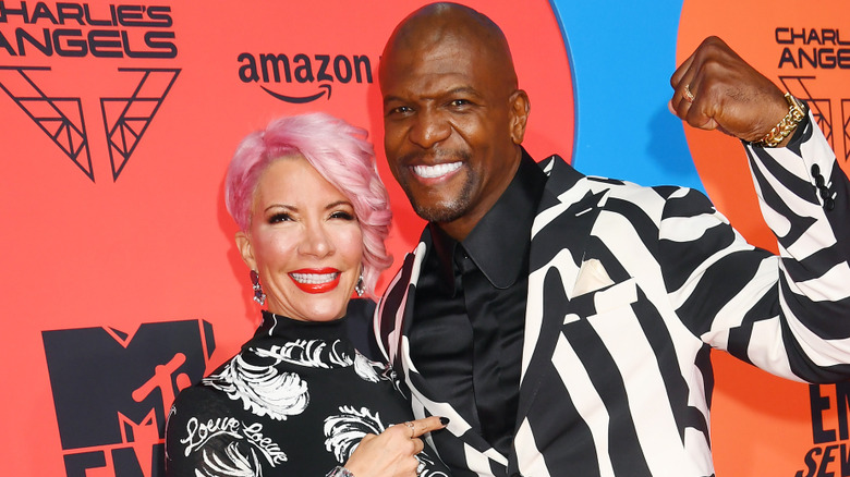 Rebecc and Terry Crews smiling while posing together