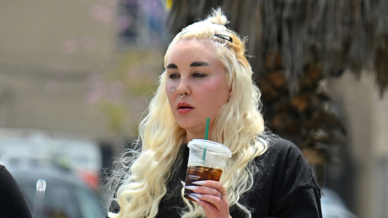 Amanda Bynes walking with a beverage in her hand in April 2024