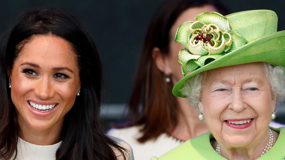 Meghan Markle smiles with the Queen