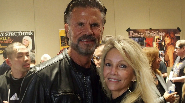 Heather Locklear hugging Lorenzo Lamas while posing together at an event