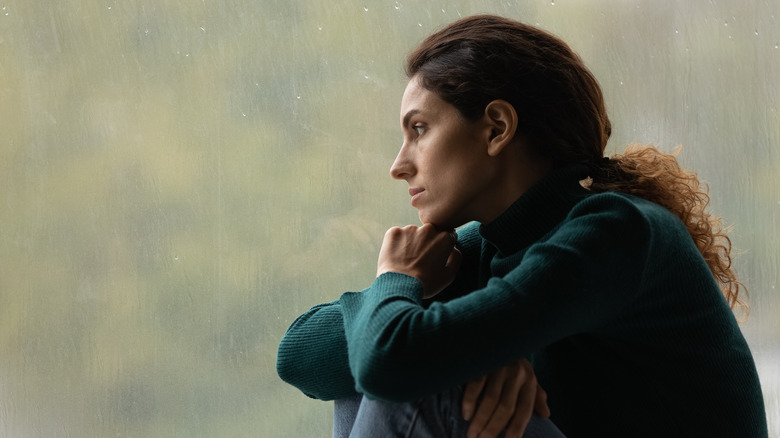 woman staring out window thinking