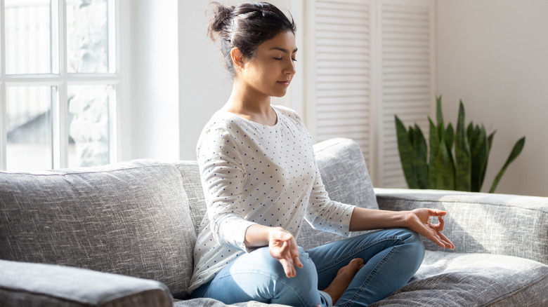 Woman sitting cross-legged on a couch
