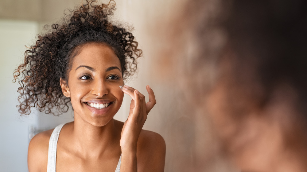 Woman applying face cream 