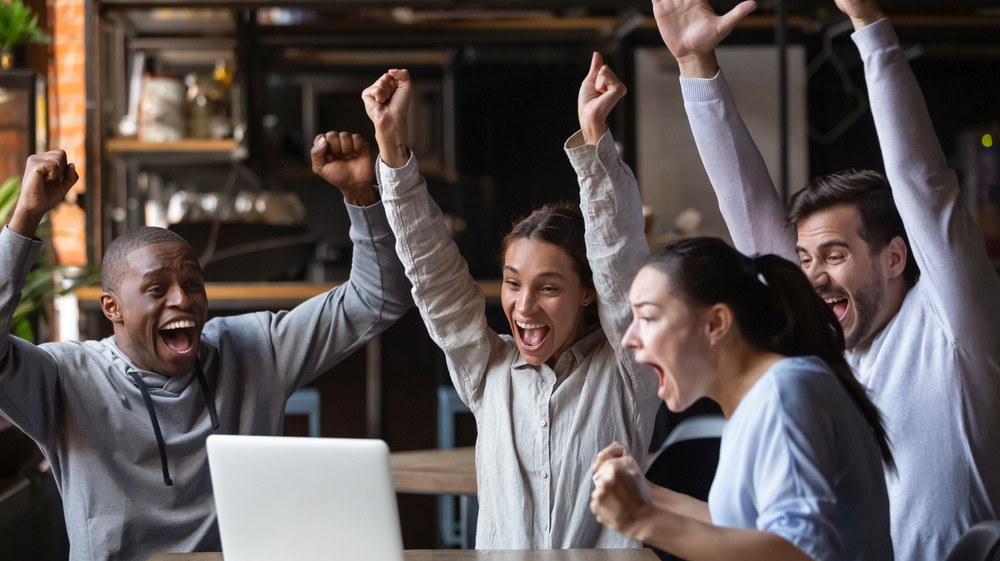 Friends cheering at a computer