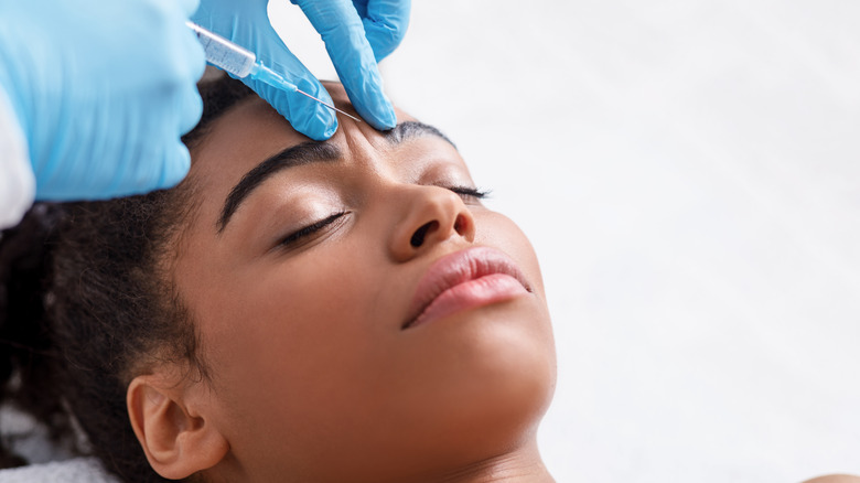 woman getting a cosmetic treatment via injectable for her wrinkles