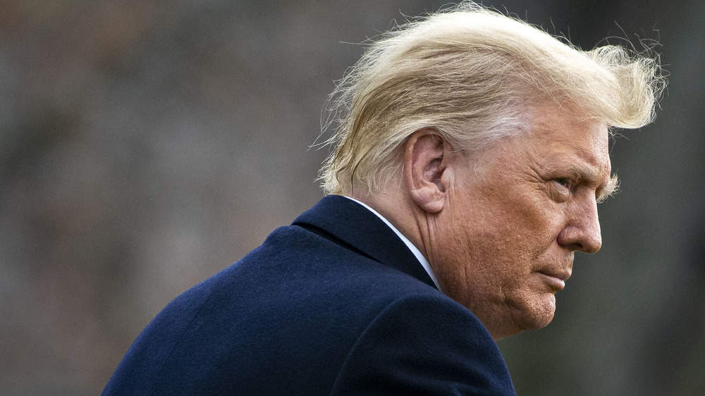 Donald Trump walking while the wind blows his hair