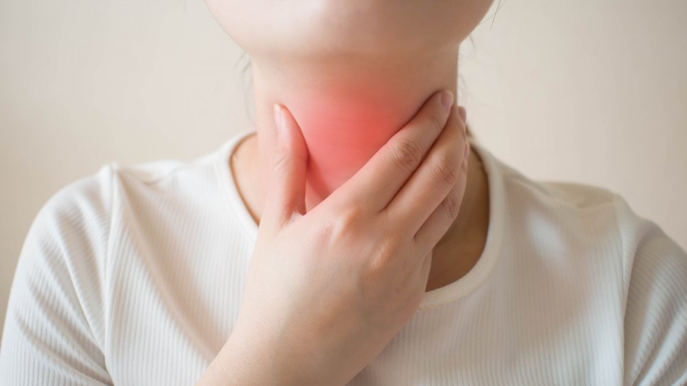 Woman holding a painful throat