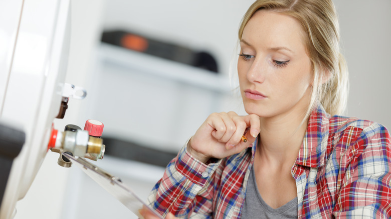 woman examining heat pump