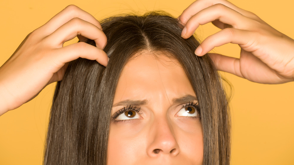 Woman scratching itchy scalp