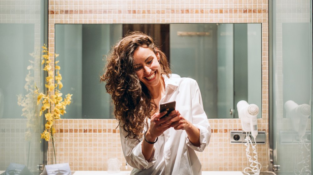 woman with phone in bathroom