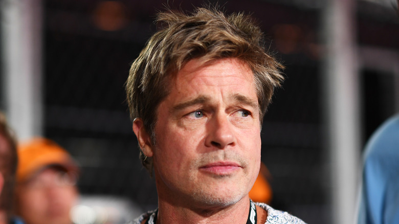 Brad Pitt frowning while looking to his left in a grey sweater