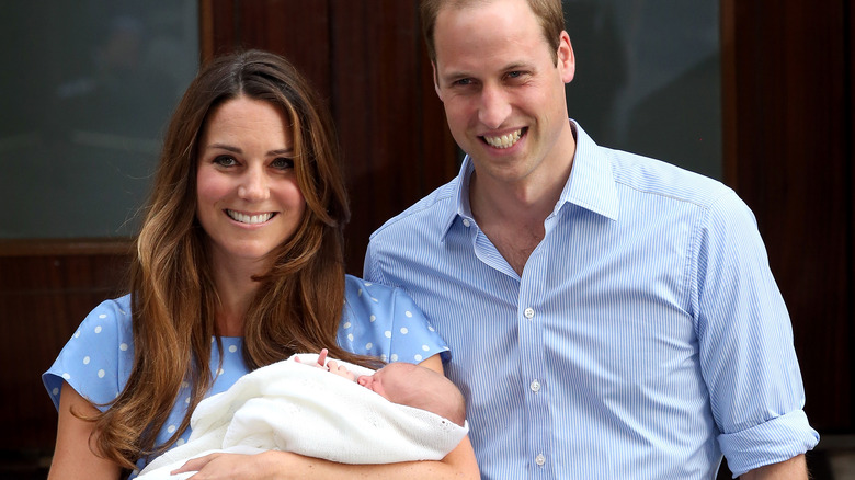 Kate Middleton and Prince William smiling with baby George