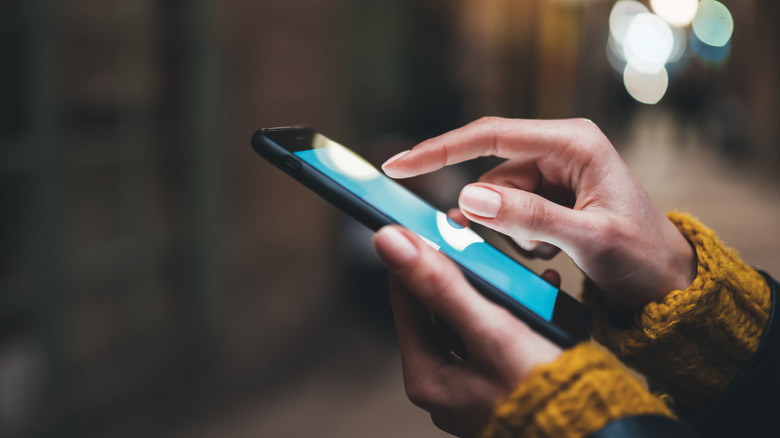woman typing on phone