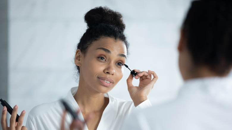 Woman putting on mascara