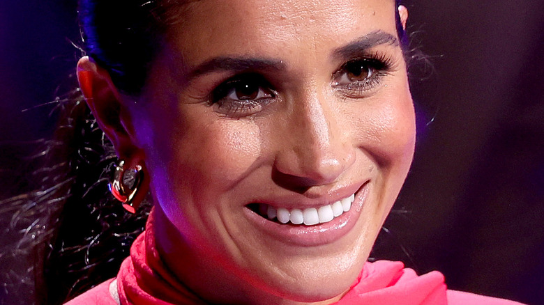 Meghan Markle smiling while giving a speech