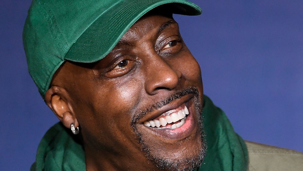Arsenio Hall smiling in green hat with facial hair