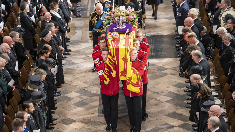 King Charles III walking behind Queen Elizabeth's coffin at her funeral