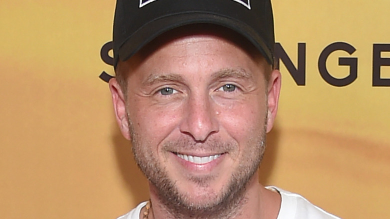 Ryan Tedder smiling in a white t-shirt