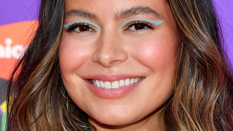 Miranda Cosgrove with wide smile and blue eye makeup