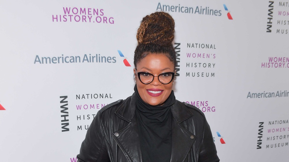 Yvette Nicole Brown smiling, wearing glasses