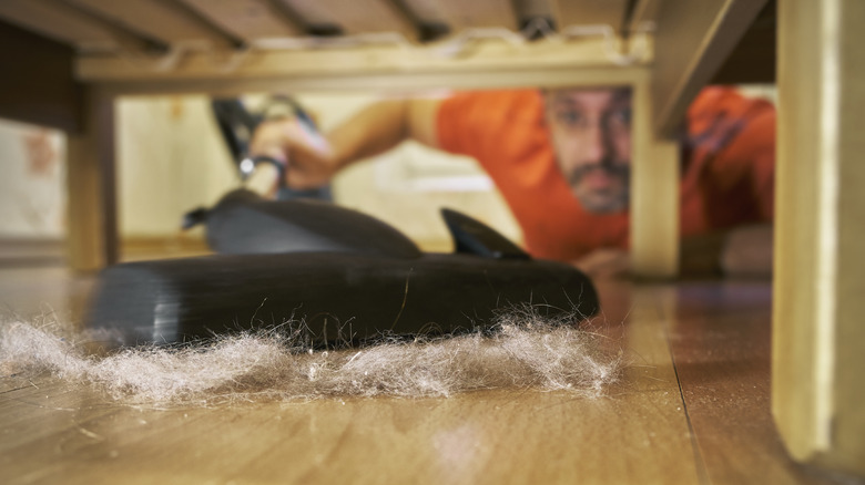 man cleaning under bed